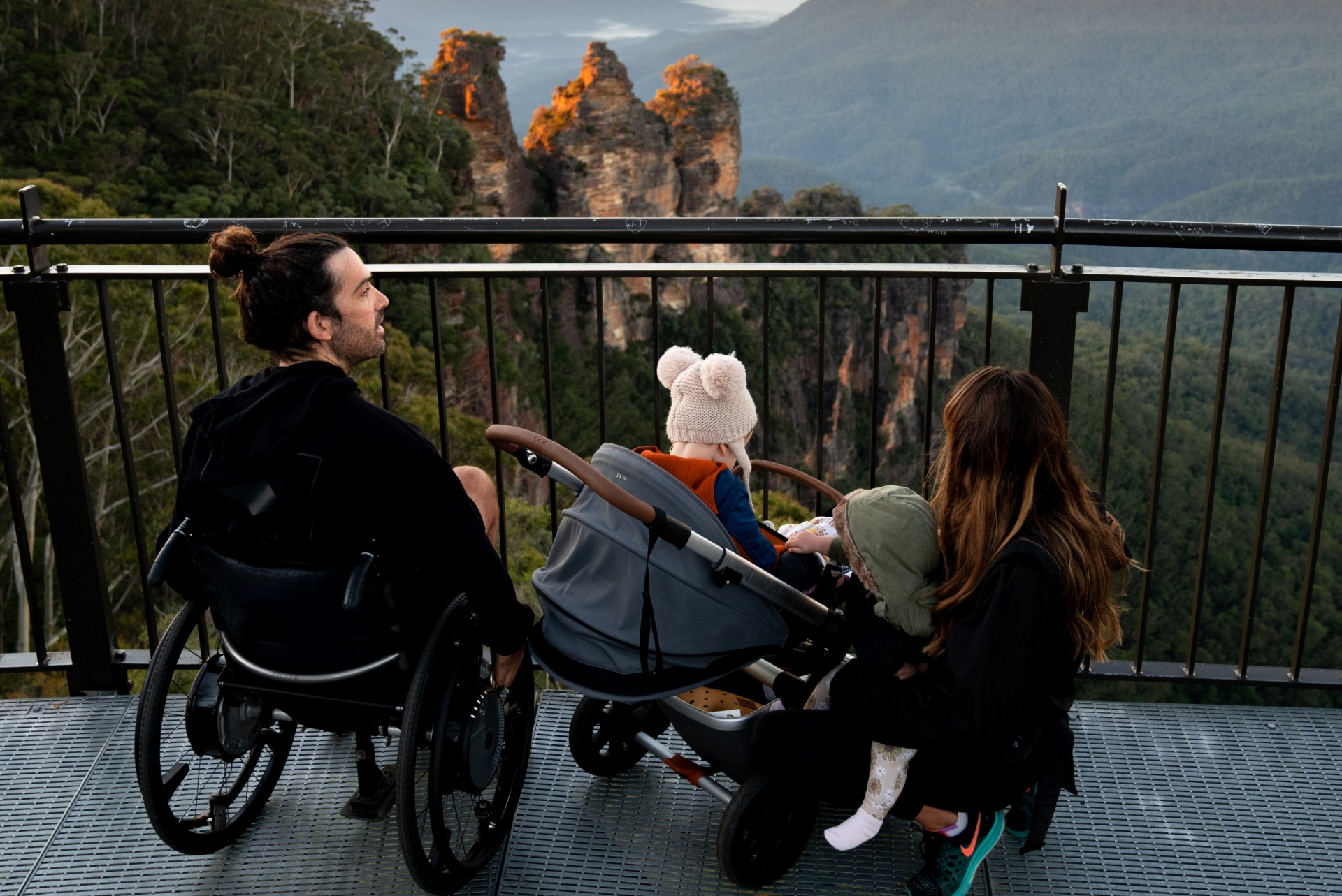 新南威尔士州，蓝山，一位坐轮椅的男子与其家人一起俯瞰三姐妹峰 © 澳大利亚旅游局版权所有