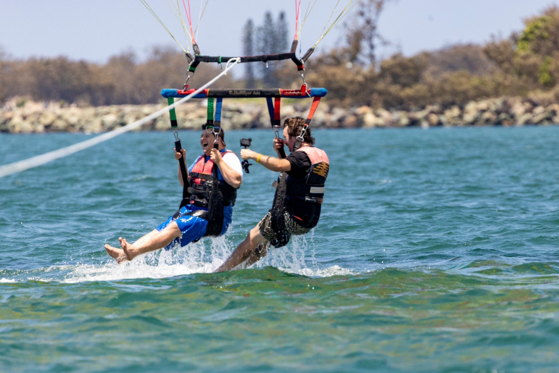 昆士兰州，黄金海岸，黄金海岸水上运动，一名患有神经分化症的男子与另一名男子一起参加滑翔伞运动 © 昆士兰州旅游及活动推广局版权所有
