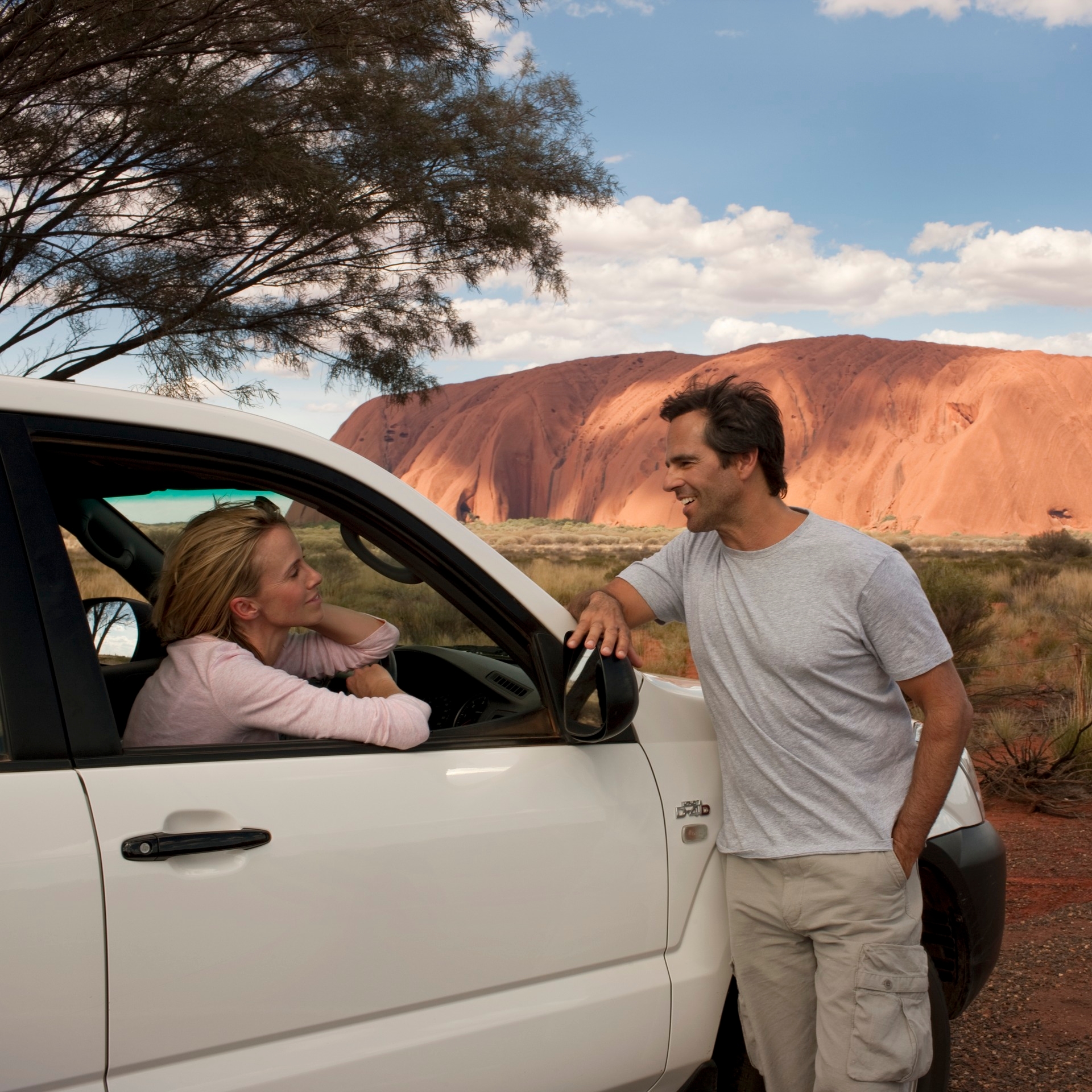 一对情侣坐在停在乌鲁鲁附近的车里 © 澳大利亚旅游局版权所有