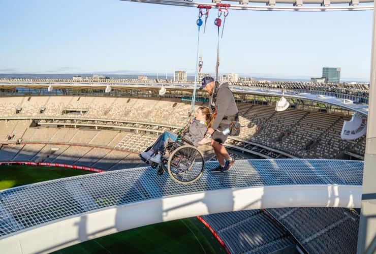 西澳大利亚州，珀斯，澳都斯体育场的 Ozone，一位坐轮椅的女子戴着安全带被推到高架通道上 © 西澳大利亚州旅游局版权所有