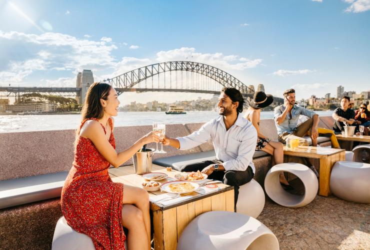 新南威尔士州，悉尼歌剧院酒吧，一对情侣一边品尝美食一边欣赏海港景色 © 新南威尔士州旅游局版权所有