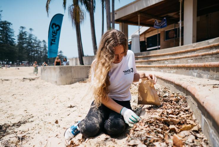 一位女士在拜伦湾的海滩清洁活动中收集垃圾 © Take 3 for the Sea 版权所有