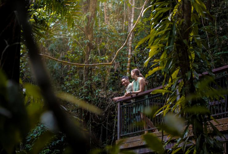 昆士兰州，戴恩树，倚靠在戴恩树生态旅舍以雨林为背景的阳台上的男女 © 昆士兰州旅游及活动推广局版权所有