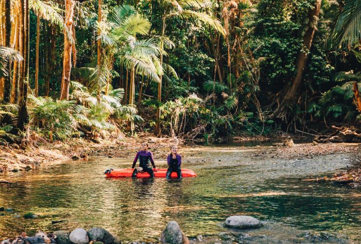 昆士兰州，戴恩树，Back Country Bliss Adventures 公司，坐在以雨林为背景的充气筏上体验河流漂流浮潜之旅的两个微笑的孩子 © 热带北昆士兰旅游局版权所有