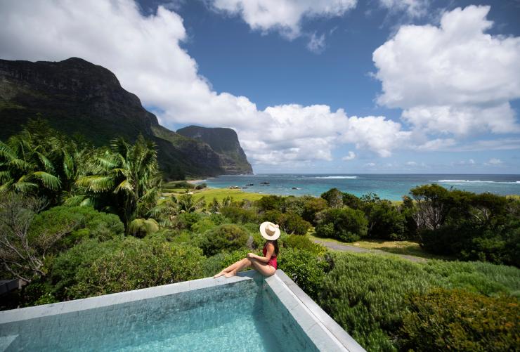 新南威尔士州，一名女性坐在泳池边俯瞰豪勋爵岛卡佩拉旅舍郁郁葱葱的风景 © Tom Archer 版权所有