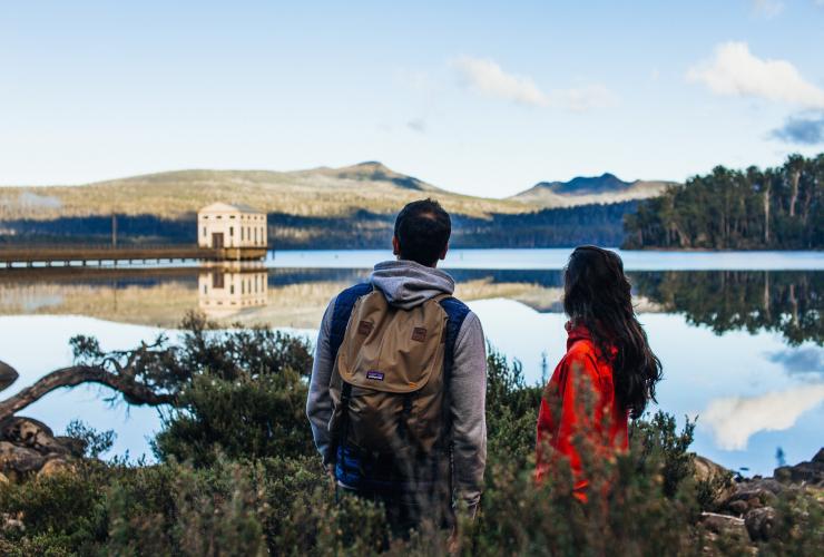 塔斯马尼亚州，圣克莱尔湖，正在徒步的情侣眺望圣克莱尔湖，远处是泵房角 © Adam Gibson 版权所有