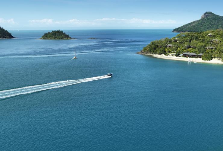 昆士兰州，汉密尔顿岛，小船驶向阔利酒店周边环绕着的白色沙滩和绿色植被 © 阔利酒店版权所有
