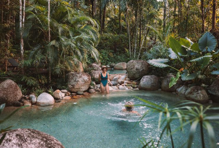 昆士兰州，戴恩树热带雨林，一对夫妇在希尔奇橡树酒店湛蓝清澈的泳池中游泳，四周是热带雨林 © 昆士兰州旅游及活动推广局版权所有